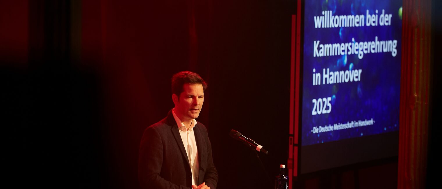 Regionspräsident Steffen Krach spricht auf der Bühne ein Grußwort.
