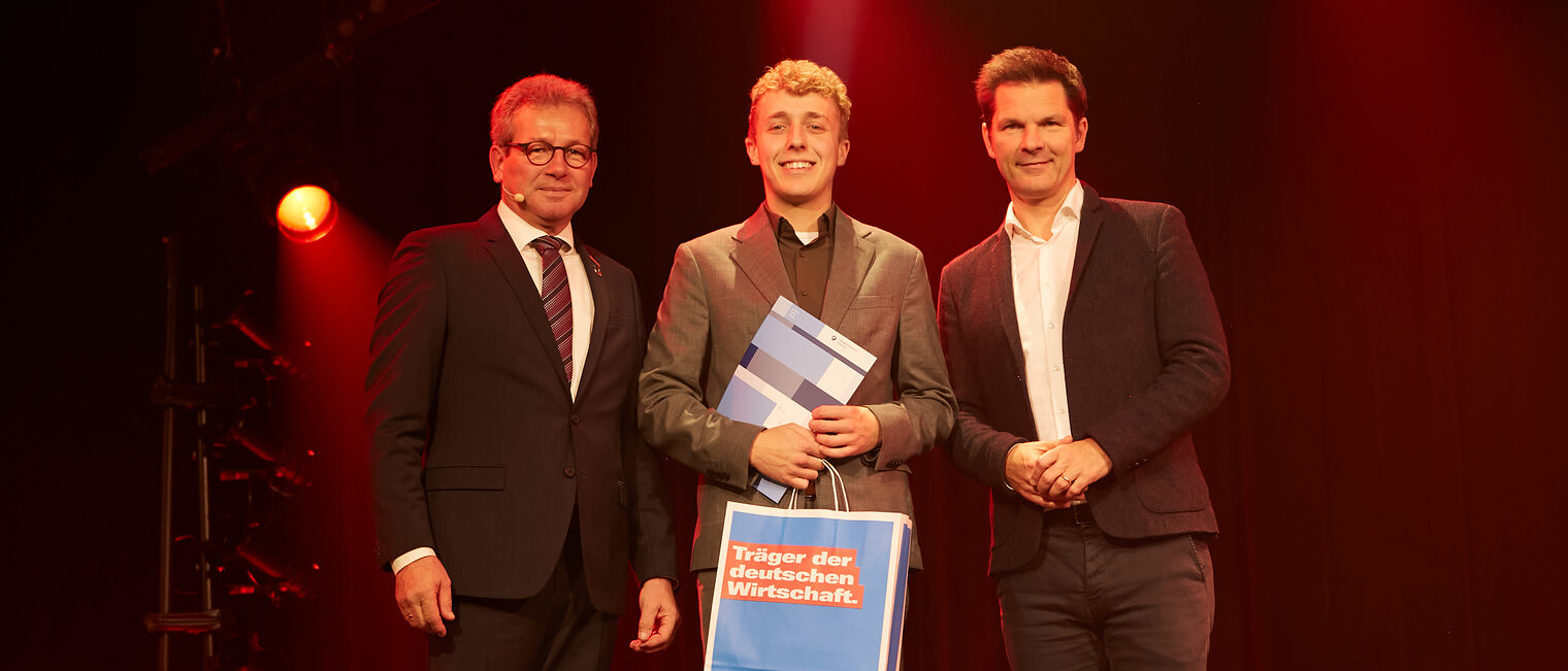 Jonas Cohrs mit Kammerpräsident Thomas Gehre (li.) und Regionspräsident Steffen Krach (re.) auf der Bühne im GOP Hannover.