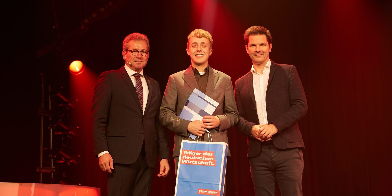 Jonas Cohrs mit Kammerpräsident Thomas Gehre (li.) und Regionspräsident Steffen Krach (re.) auf der Bühne im GOP Hannover.