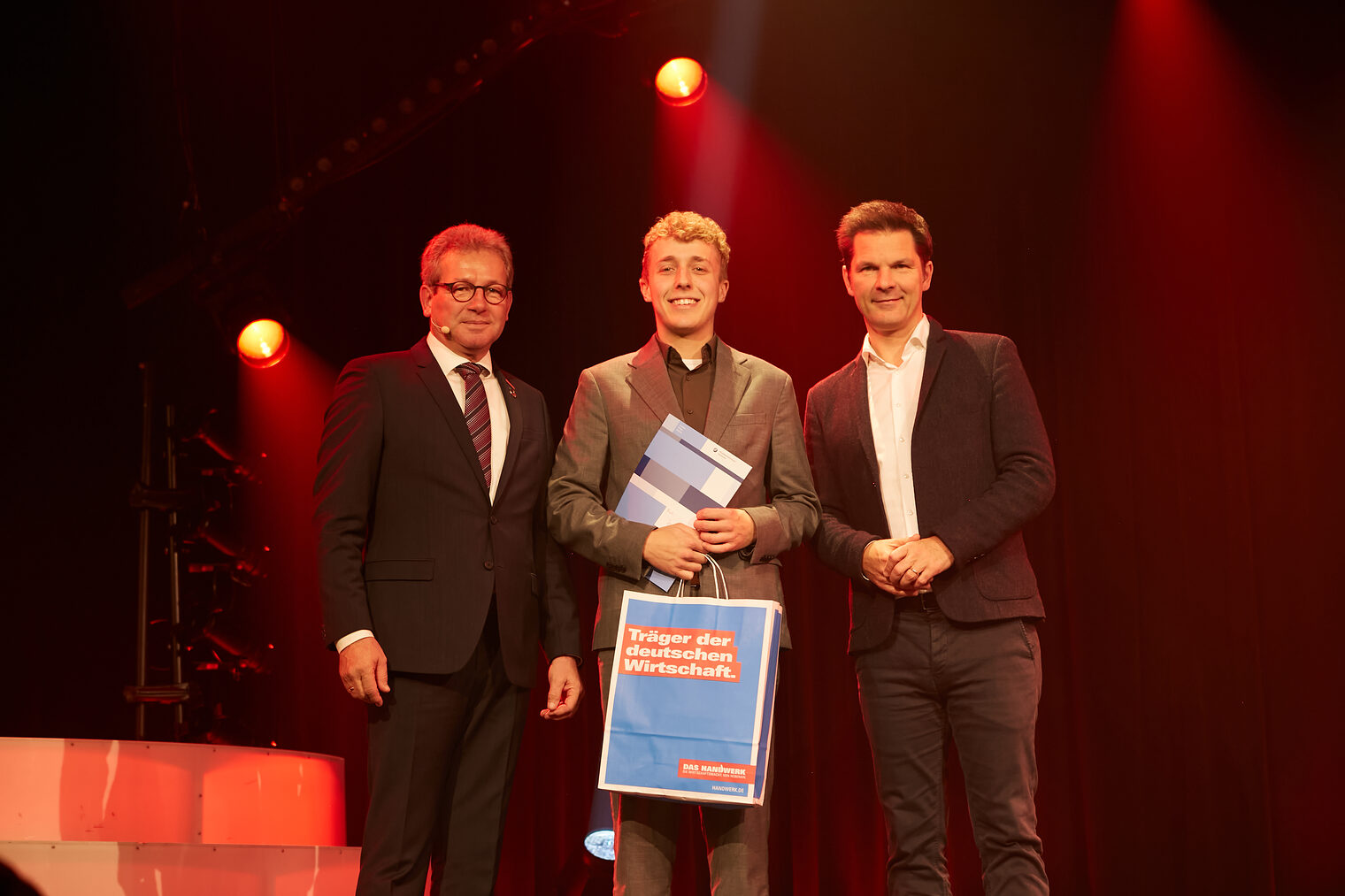 Jonas Cohrs mit Kammerpräsident Thomas Gehre (li.) und Regionspräsident Steffen Krach (re.) auf der Bühne im GOP Hannover.