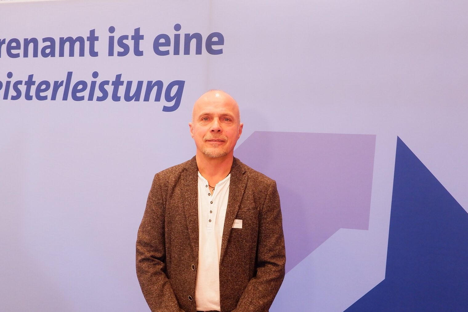 Andreas Güttlein steht vor einem Rollup Ehrenamt ist eine Meisterleistung.