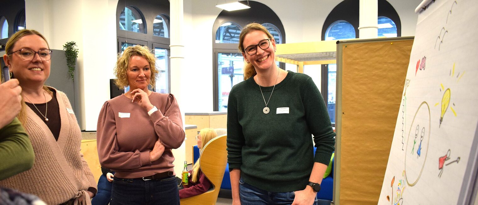 Drei Frauen stehen stehen vor Metaplan in einem Workshop.