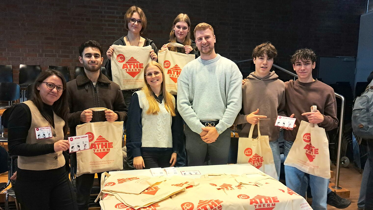 Acht Personen präsentieren die Werbesticker.