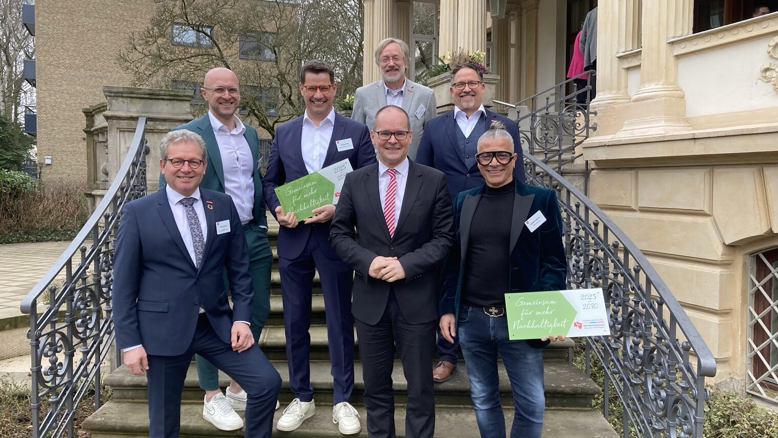 Die ausgezeichneten Betriebe mit Minister und Handwerkskammerpräsident und weiteren Personen stehen auf einer Treppe des Gästehauses der niedersächsischen Landesregierung.