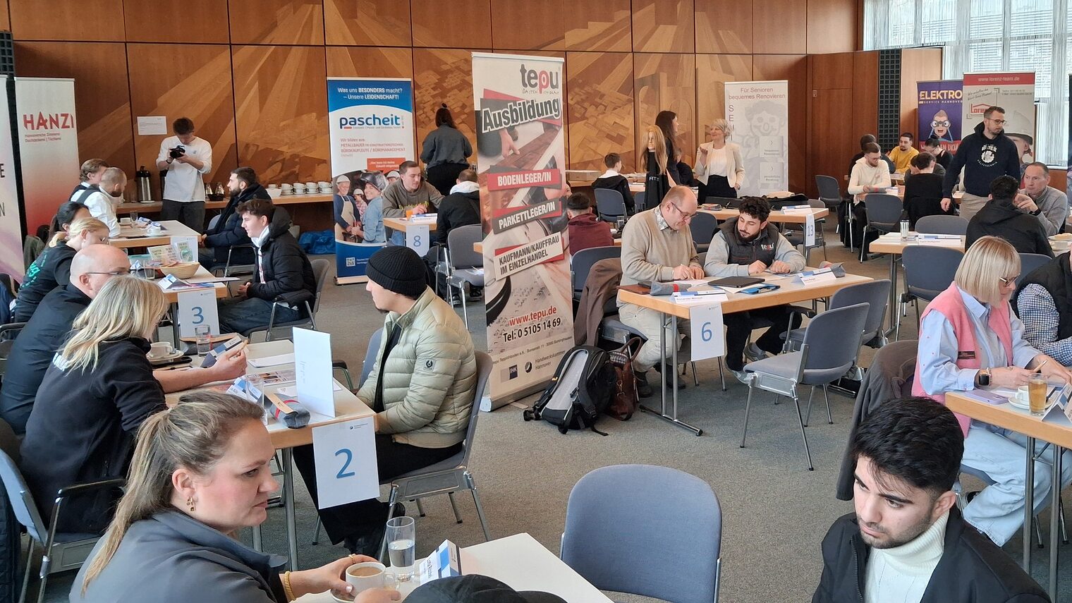 Menschen an Tischen beim Azubi Speed Dating