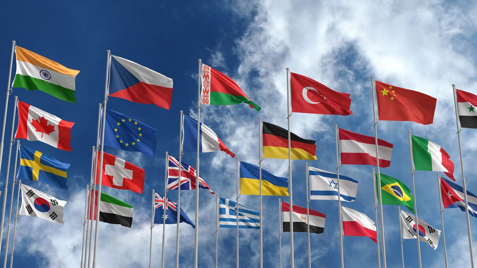 Fahnen verschiedener Nationen ragen in den Himmel.