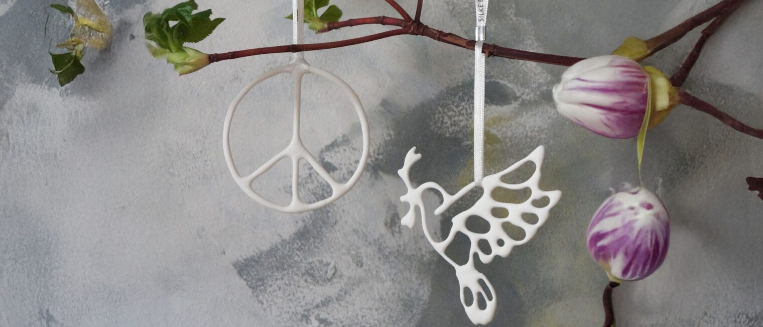 Anhänger aus Keramik: Peace-Zeichen und Taube an einem Ast.