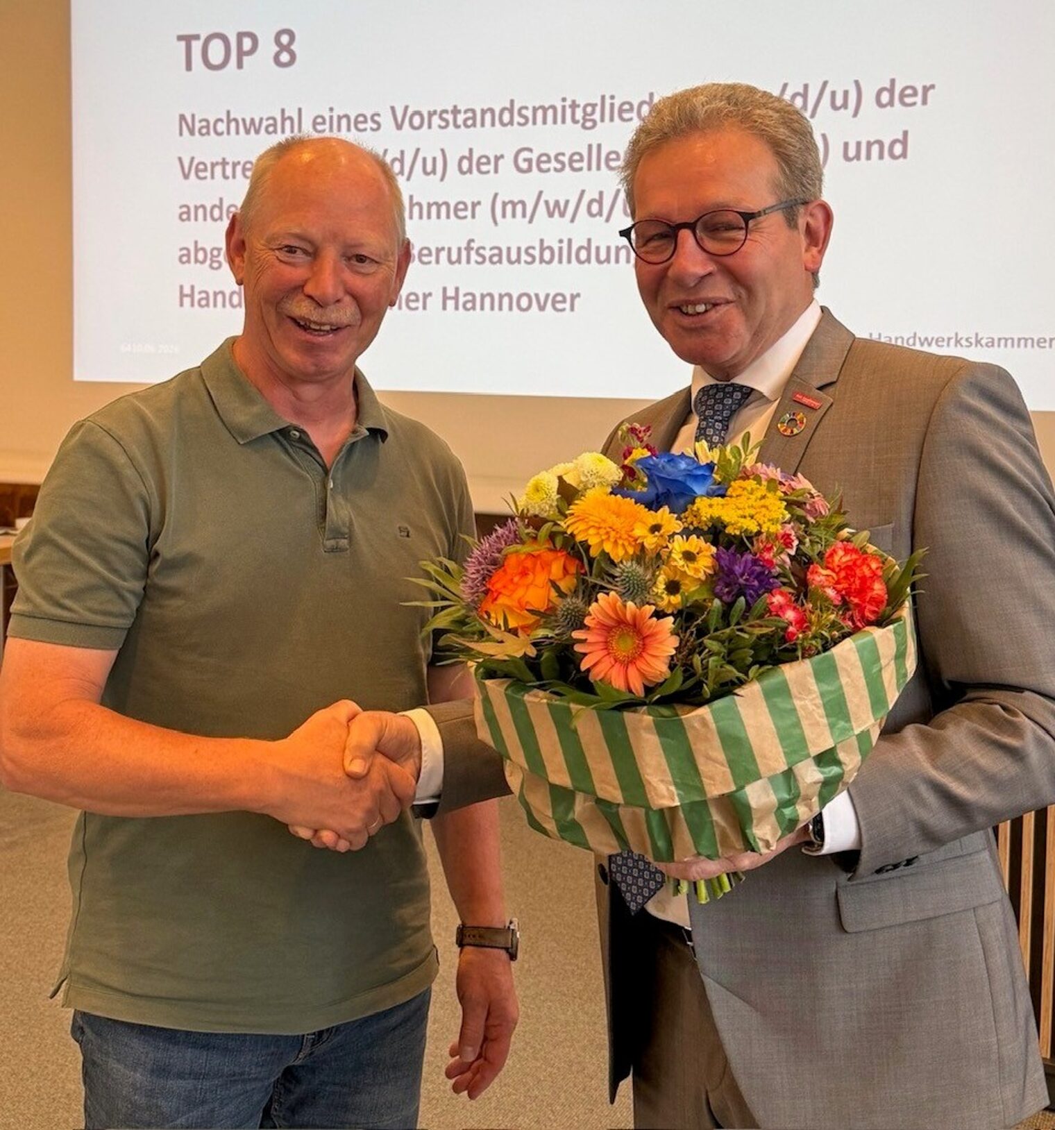 Dirk Blech bekommt von Kammerpräsident Thomas Gehre einen Blumenstrauß.