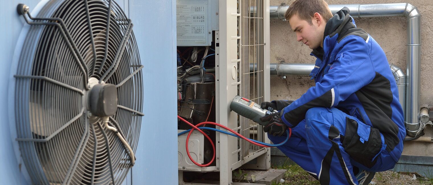 Mechatroniker für Kältetechnik misst Werte bei einer Wärmepumpe.