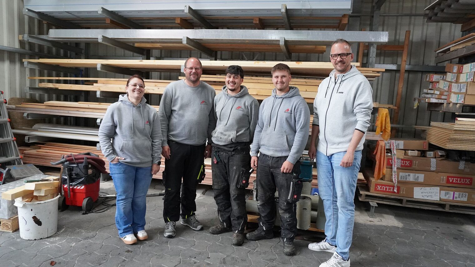 Team der Dachdeckerei alles beDacht mit Ausbildungsberater Christian Bunzel stehen zusammen in der Bauhalle.