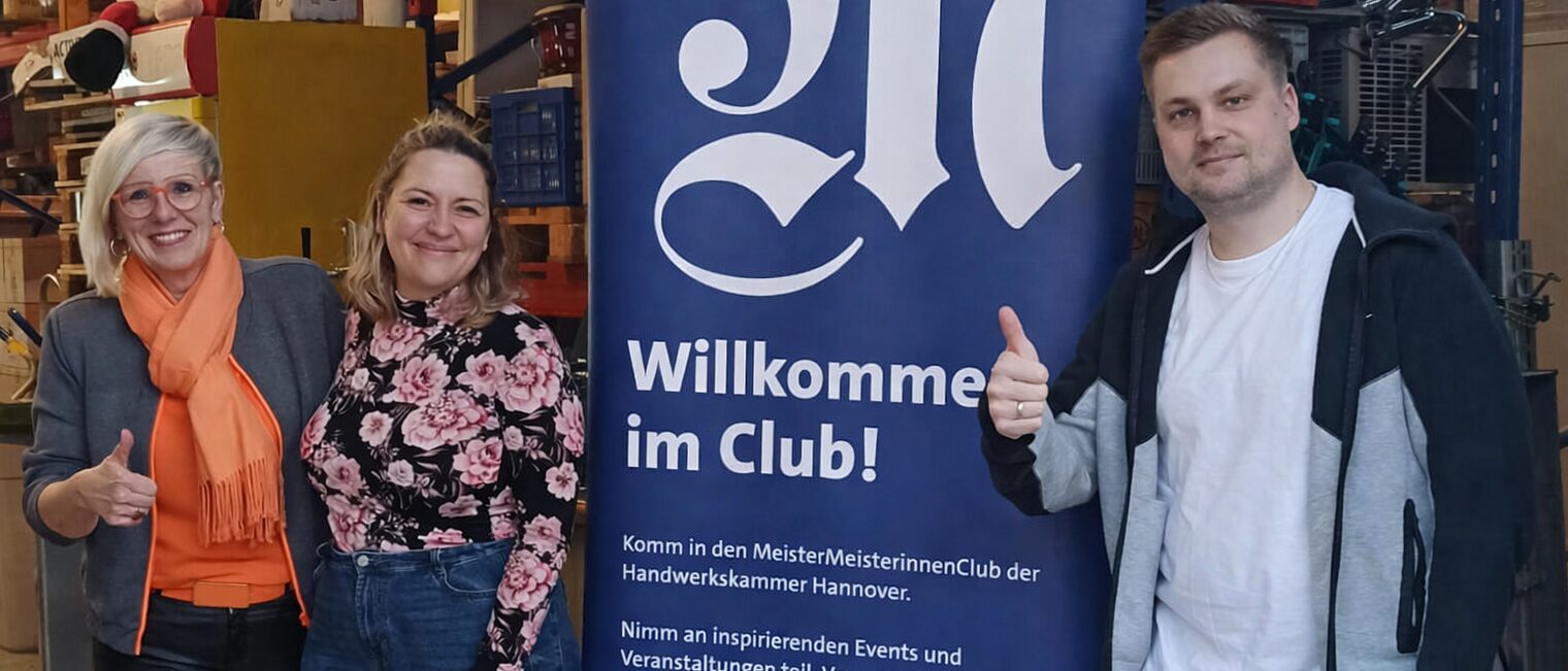 Die MMC-Koordinatoren Stephanie Fischer, Eva Tymko und Dennis Weiß vor einem MMC-Rollup.
