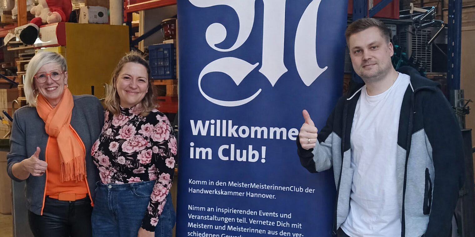 Die MMC-Koordinatoren Stephanie Fischer, Eva Tymko und Dennis Weiß vor einem MMC-Rollup.