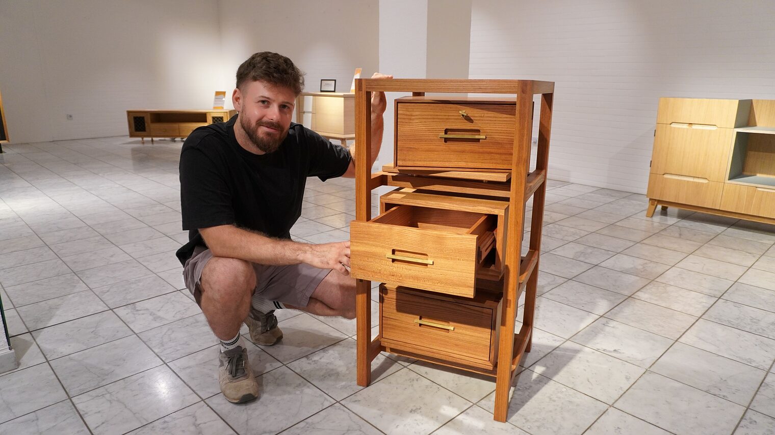 Tischlermeister Jannes Kmoch zieht eine Schublade an seiner Schubkastensäule raus.